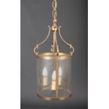 A brass cylindrical three glass hall lantern with three branches and milled decoration, 56cm high,