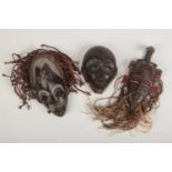 Three West African carved wooden tribal masks. Two with pigment decoration and rope hair.