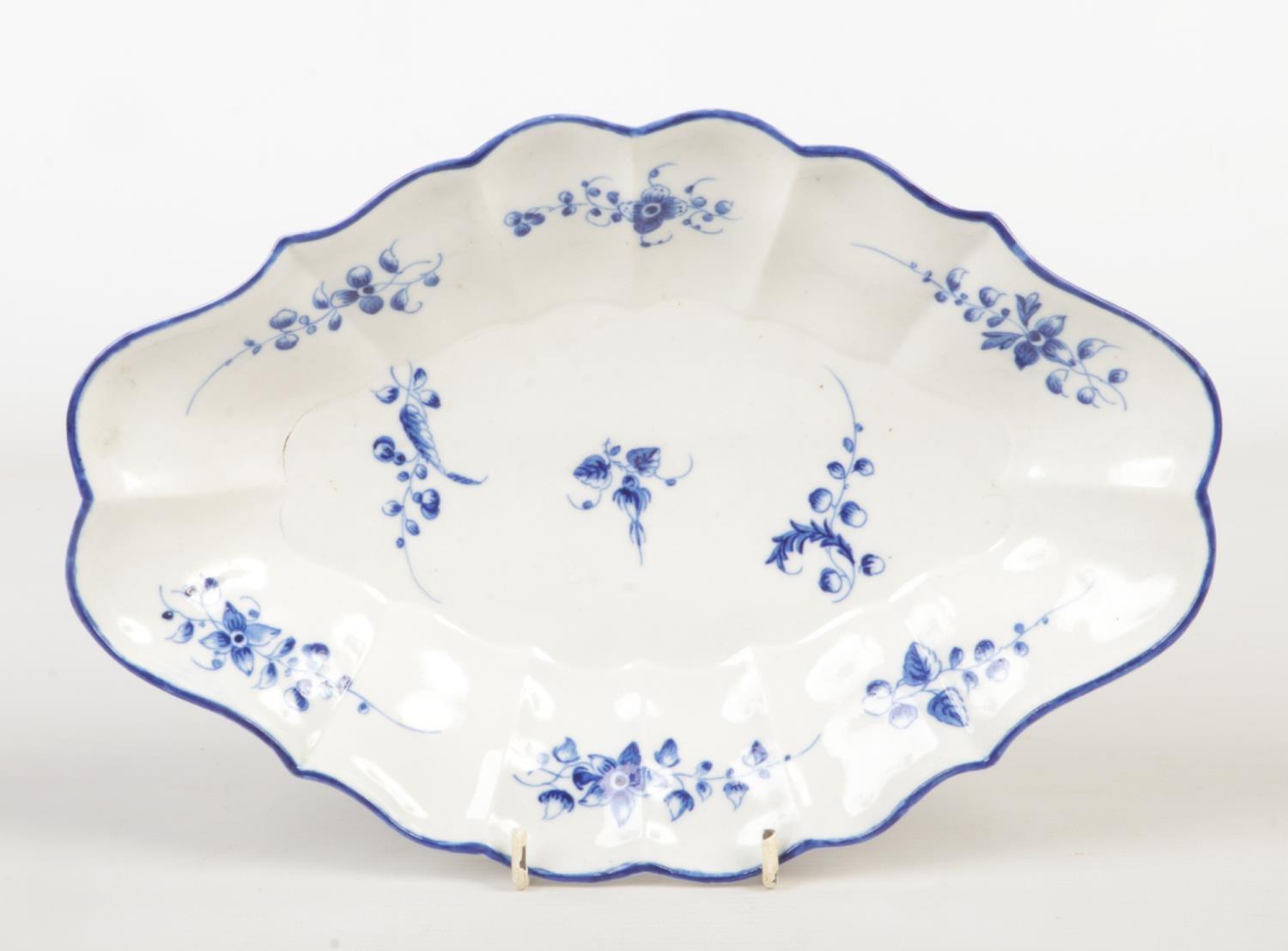 A Caughley scalloped dessert dish. Painted in underglaze blue with scattered sprigs under a blue