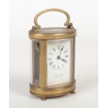 A 19th century oval brass carriage clock retailed by J. Shaw & Son, Manchester. With enamel dial and