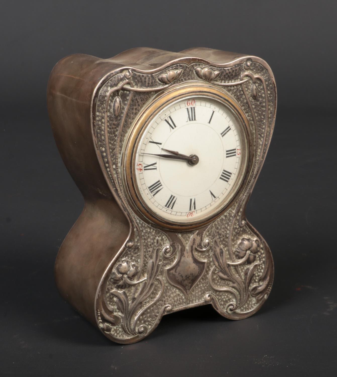 An Art Nouveau silver cased desk clock by Douglas Clock Co. Decorated in relief with stylized