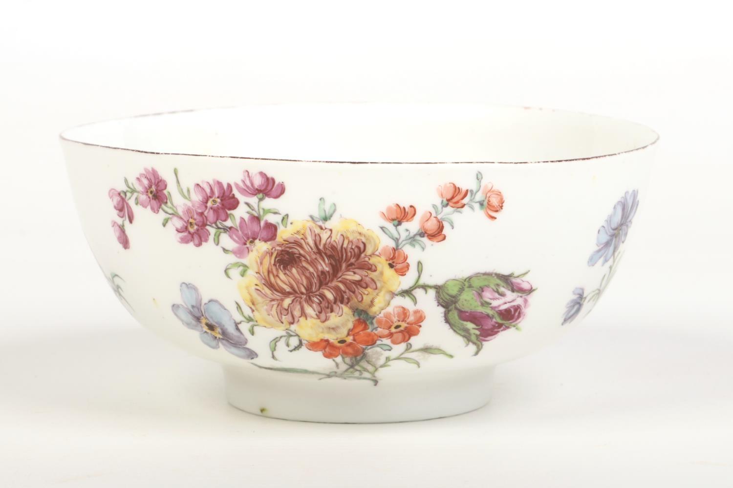 A Chelsea bowl of plain thrown form. Painted in coloured enamels in the Meissen style with flowers