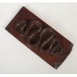 An antique carved oak rectangular plaque decorated with a coiled snake. Probably a panel formerly