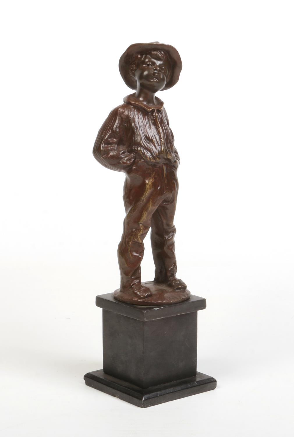 A bronze figure of a young boy raised on a square slate plinth. Modelled smoking a cigar, stood with