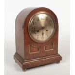 An Edwardian oak cased dome top mantel clock. With silvered dial having Arabic numeral markers.