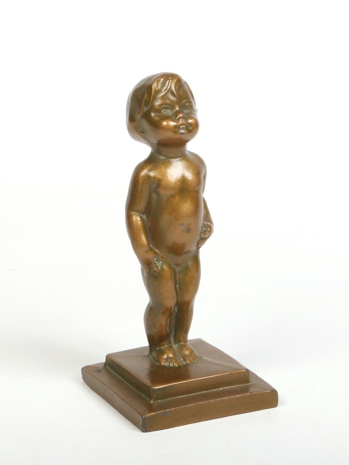 An Art Deco cast gilt metal figure of an infant raised on a stepped plinth. Signed verso