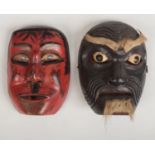 Two Japanese wooden Noh (theatre) masks, carved and with painted decoration, one with applied hair.