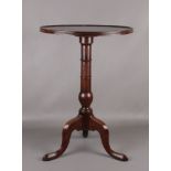 A George III mahogany dish topped tripod wine table. Raised on a gun barrel column over three