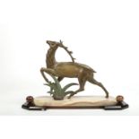 An Art Deco cold painted spelter model of a Royal Deer raised on an onyx, marble and slate plinth.