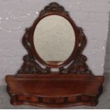An ornate carved oak dressing table mirror with drawer base.