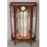 A mahogany display cabinet with fitted Smith's clock to the top, raised on small cabriole supports.