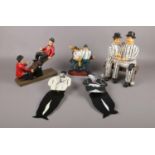 A group of Laurel & Hardy ceramic figures, sat on a see- saw, in prison uniform, to include swing