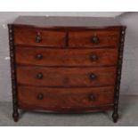 A mahogany bow front chest of 2 over 3 drawers with turned column supports. (107cm x 113cm) Veneer