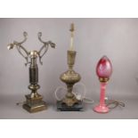 Three table lamps, two ornate brass lamps and ceramic pink lamp with cranberry glass shade