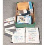 A box of British stamps, stamp auction catalogues, wooden Royal Mail storage box etc.