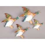 Four ceramic Beswick flying ducks. Outstretched wing of the larger duck repaired.