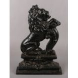 A black painted cast iron doorstop, formed as a lion. (Height 37cm).