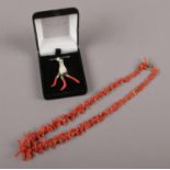 A coral necklace, along with a mother of pearl and coral pendant on silver chain.