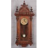 A ornate carved mahogany 8 day wall clock with gilt and roman numeral marker dial. Top left finial