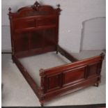 An ornate carved mahogany French double bed frame. One finial snapped and broken.