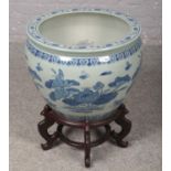 A large decorative oriental blue & white ceramic bowl on wooden stand. (66cm x 55cm on stand)