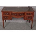 A mahogany leather top desk raised on slender tapering legs. (76cm x 122cm)