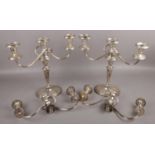 A pair of silver plate candelabra along with two extra candelabra tops.