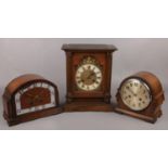 Two carved oak dome top mantel clocks along with a larger mantel clock with gilt dial.
