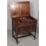 A carved oak gramophone with barley twist supports.