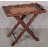 An ornate carved oak tray on stand decorated with leaves. (Total height 65cm, Tray size 68cm x