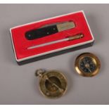 A boxed George Wostenholm pen knife and blade sharpener, along with two brass compasses, one with