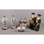 A group of Laurel & Hardy ceramic figures, sat on suitcases, to include salt & pepper pots Hardy