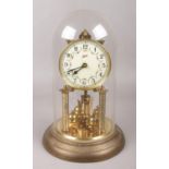 A Schatz brass torsion clock under glass dome, height 30cm.