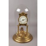 A brass torsion clock under glass dome, the movement stamped Urania, height 32cm. Pendulum broken.