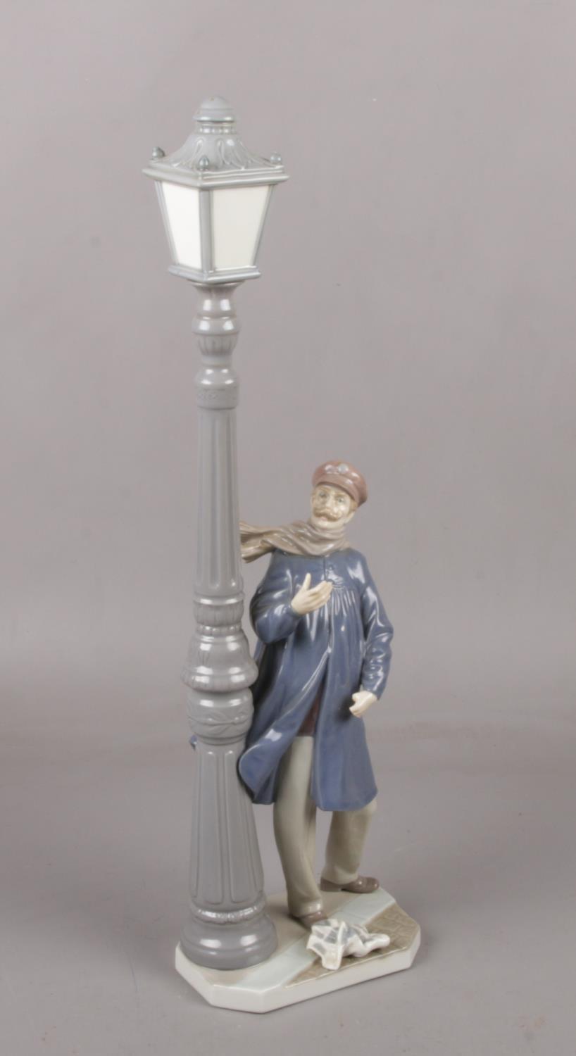 A Large Lladro figure of man and a street lamp, 47cm height Fingers and thumb missing on left