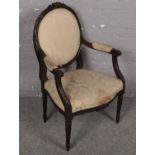 A French style carved mahogany upholstered armchair raised on reeded supports.