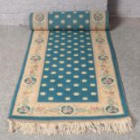 A blue ground Chinese wool runner. (320cm x 80cm).