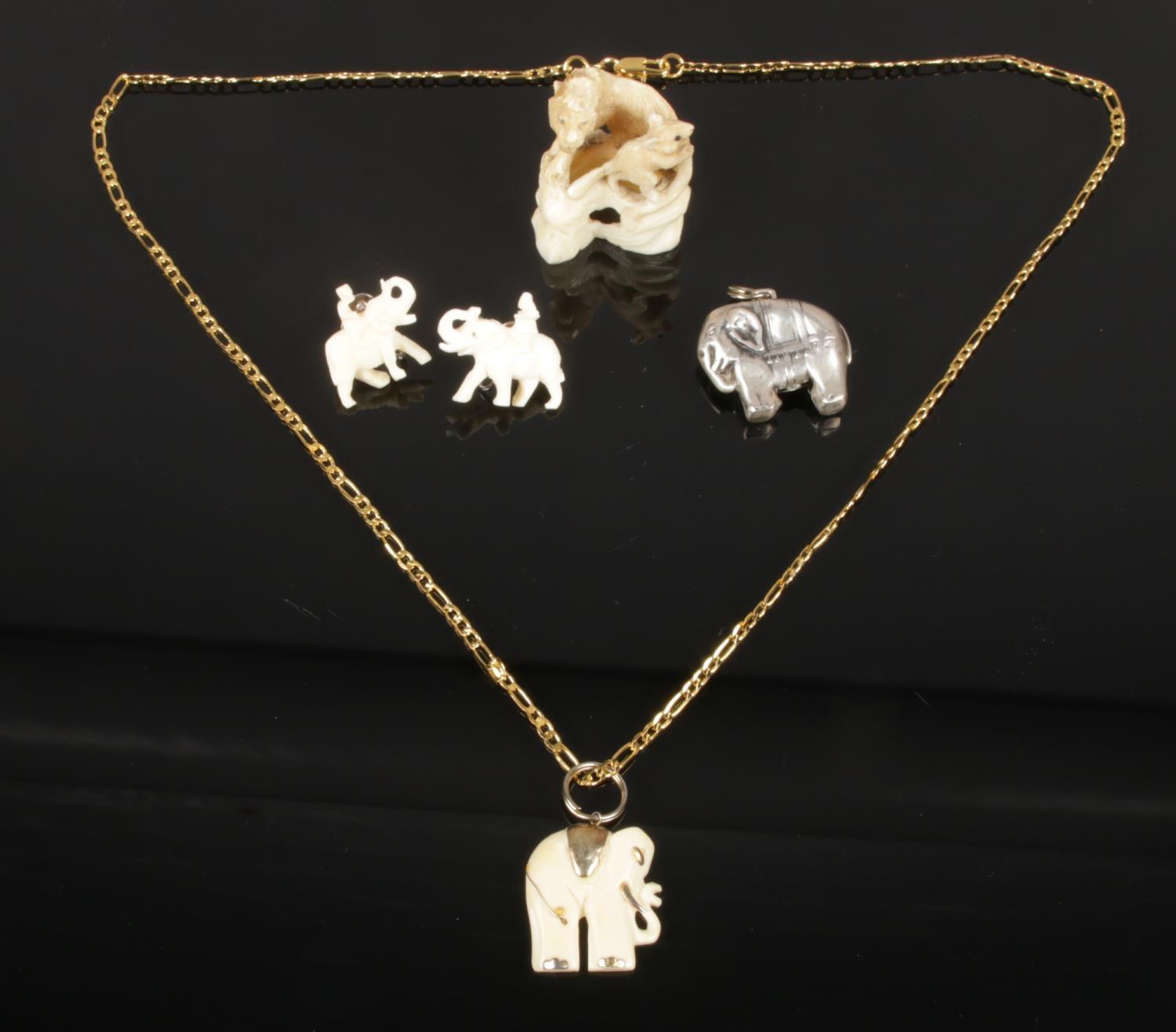 A selection of ivory jewellery, including an ivory miniature carving of a lion and mouse, an ivory