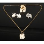 A selection of ivory jewellery, including an ivory miniature carving of a lion and mouse, an ivory