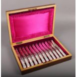 A mahogany cased set of twelve Walker & Hall mother of pearl handled dessert knives and forks.