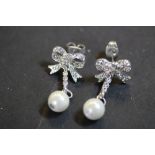 Pair CZ & white metal bow earrings with faux pearl pendant