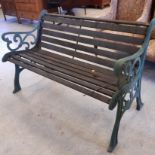 Green cast metal garden bench with wood slats