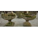 Pair of reconstituted garden urns with leaf scroll borders