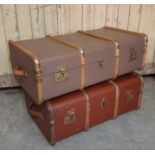 Two early 20th Century wood bound and canvas covered cabin trunks, the larger fawn coloured in