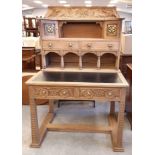 Scottish Arts & Crafts brass mounted carved oak desk, the superstructure with open niches and fitted