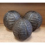 Three leaf carved hardwood balls, possibly New Zealand, two 13cm diameter, the other 9.5cm diameter