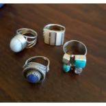 Four Continental silver and white metal rings, variously set with lapiz lazuli and other stones