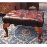Buttoned maroon leather rectangular footstool, on cabriole legs, 54cm x 40cm x 33cm high