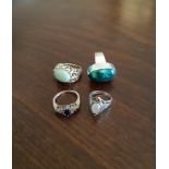 Four silver rings, variously set with moonstone, malachite and other stones