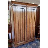 Late Victorian pitch pine wardrobe of Arts & Crafts design, with ebonised highlights, fitted sliding